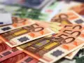 Stos banknotów euro, w tym 50 euro. Zastanawiasz się, arbeidskorting co to? To ulga podatkowa dla pracujących.