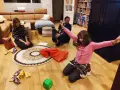 Rodzina świętuje Dzień Mamy w Holandii. Dzieci z radością otwierają prezenty, a tata obserwuje ich zabawę.