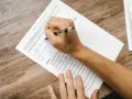 Osoba wypełnia formularz podatkowy, wpisując dane. Pytania dotyczą rezydencji podatkowej i dochodów.