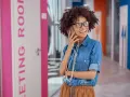 Vrolijke vrouw met bril belt op, mogelijk een recruiter in Nederland die een nieuwe baan regelt.