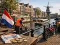 Euro's op tafel in Amsterdam, met een Nederlandse vlag. Droom je van praca holandia 500 euro tygodniowo?