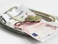 Na tacy leżą rachunek, banknot 10 euro i dwie monety. Tak wyglądają napiwki w Holandii.