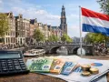 Eurobiljetten, munten en een rekenmachine op een tafel met Amsterdamse grachten op de achtergrond. Hoeveel verdient een arts in Nederland?
