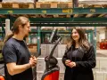 Pracownicy easywork uitzendbureau rozmawiają w magazynie, otoczeni paletami z produktami.