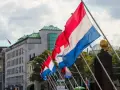 Holandia świętuje! Rząd flag narodowych powiewa na wietrze przed nowoczesnym budynkiem.