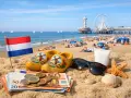 Holenderska flaga, drewniaki, pieniądze i okulary przeciwsłoneczne na plaży. Idealne wakacje w Holandii!