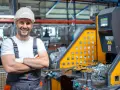 Larex: een lachende arbeider in een fabriek, klaar voor nieuwe uitdagingen. Ontdek onze vacatures!