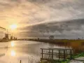 Wiatraki nad kanałem w Holandii, zachód słońca. Czy Wielki Piątek jest wolny w Holandii?