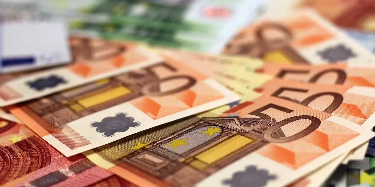 Stos banknotów euro, w tym 50 euro. Zastanawiasz się, arbeidskorting co to? To ulga podatkowa dla pracujących.