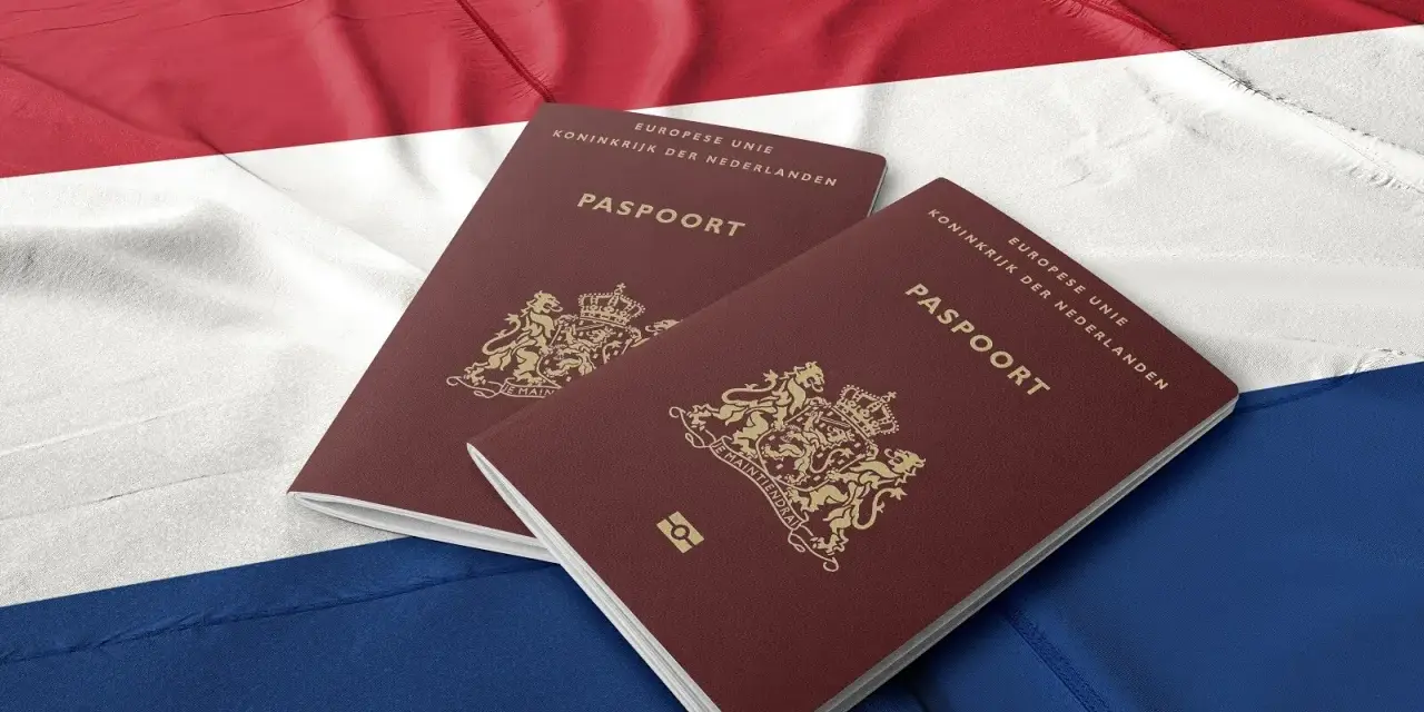 Dwa holenderskie paszporty na tle flagi Holandii. Dokumenty te mogą być kluczem do nowego życia dla wielu Polaków.