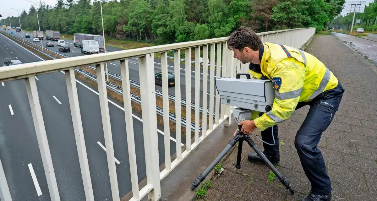 Policjant w Holandii ustawia radar na moście, by egzekwować przepisy drogowe.