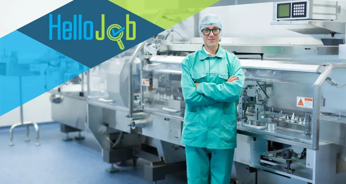 Pracownik w czepku i zielonym uniformie stoi przed linią produkcyjną. Szukasz pracy? Sprawdź cervo oferty pracy!