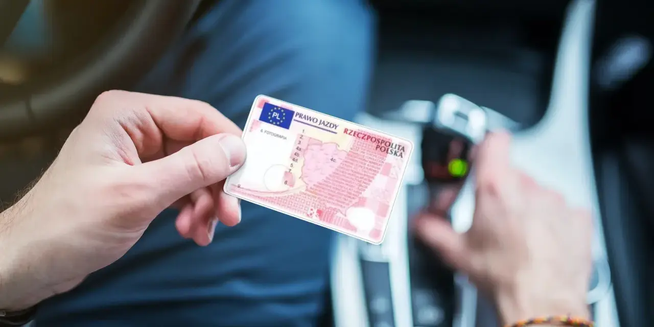 Polak trzyma polskie prawo jazdy w samochodzie. Dokument jest ważny w całej Unii Europejskiej, w tym w Holandii.