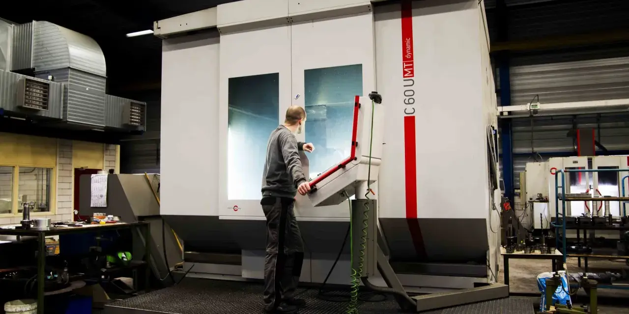 Pracownik obsługuje maszynę CNC w zakładzie w Lelystad.