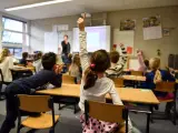 Dzieci na lekcji w Holandii, z podniesionymi rękami. Dowiedz się, jak zapisać dziecko do szkoły w Holandii.
