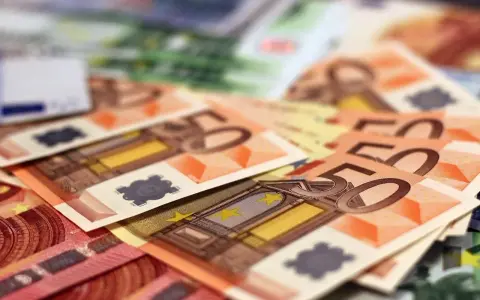 Stos banknotów euro, w tym 50 euro. Zastanawiasz się, arbeidskorting co to? To ulga podatkowa dla pracujących.