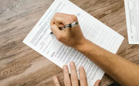 Osoba wypełnia formularz podatkowy, wpisując dane. Pytania dotyczą rezydencji podatkowej i dochodów.
