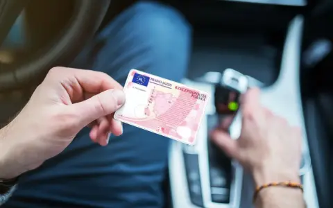 Polak trzyma polskie prawo jazdy w samochodzie. Dokument jest ważny w całej Unii Europejskiej, w tym w Holandii.