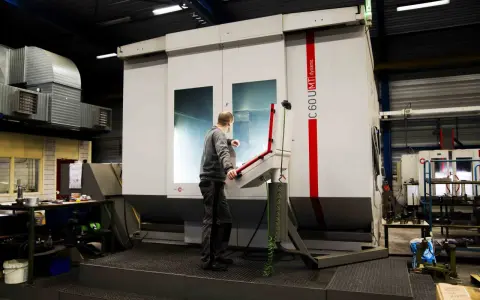 Pracownik obsługuje maszynę CNC w zakładzie w Lelystad.