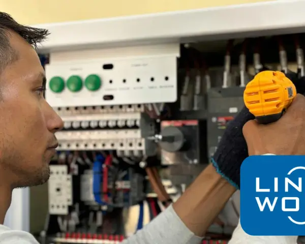 Elektryk w Holandii pracuje przy panelu sterowania.