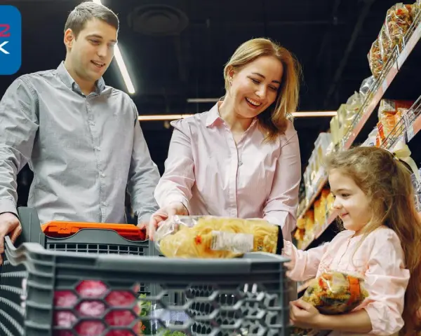 Rodzina robi zakupy w tanich sklepach spożywczych w Holandii. W wózku makaron i inne produkty.