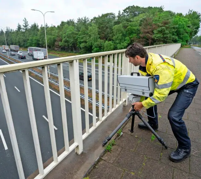 Policjant w Holandii ustawia radar na moście, by egzekwować przepisy drogowe.