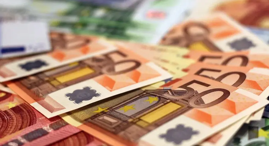 Stos banknotów euro, w tym 50 euro. Zastanawiasz się, arbeidskorting co to? To ulga podatkowa dla pracujących.
