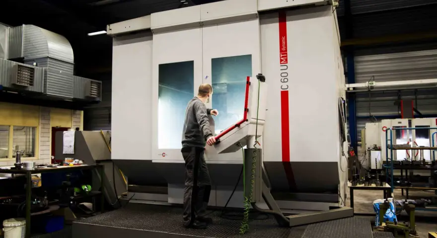 Pracownik obsługuje maszynę CNC w zakładzie w Lelystad.