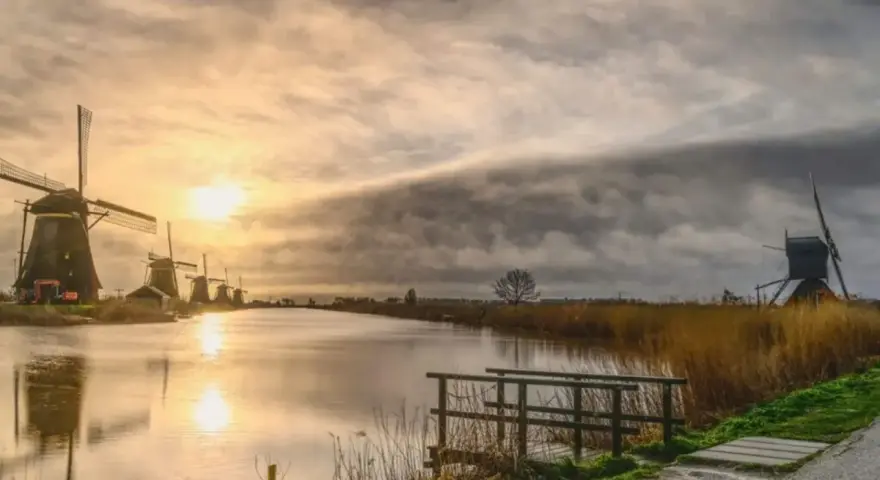 Wiatraki nad kanałem w Holandii, zachód słońca. Czy Wielki Piątek jest wolny w Holandii?