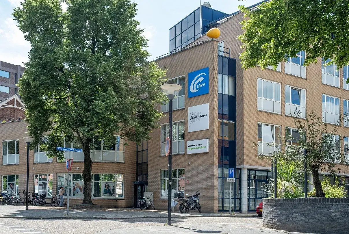 Budynek UWV w Amersfoort, gdzie można szukać pracy. W tle drzewa i rowery.