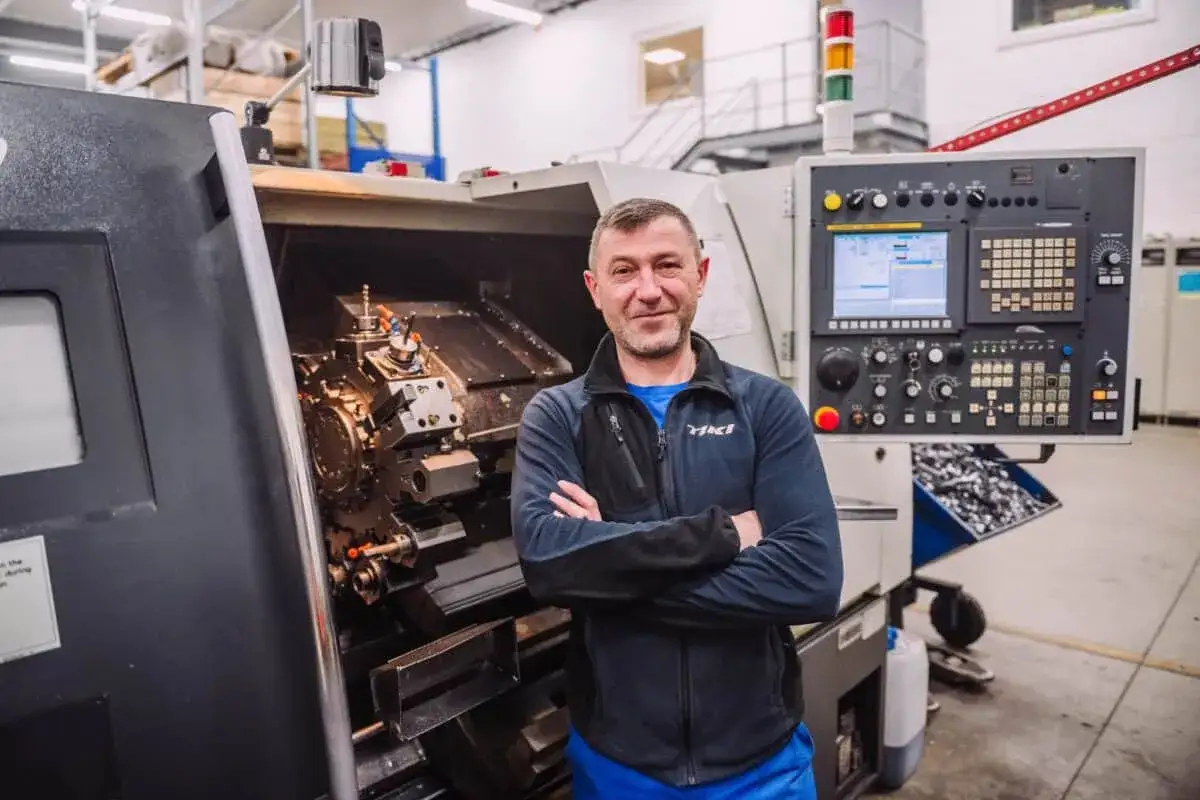 Pracownik w Holandii przy maszynie CNC. Nowe możliwości rozwoju zawodowego w branży obróbki metali.