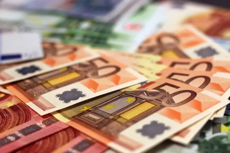 Stos banknotów euro, w tym 50 euro. Zastanawiasz się, arbeidskorting co to? To ulga podatkowa dla pracujących.
